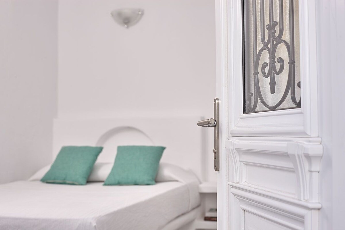 Una puerta blanca con un panel decorativo de metal y un picaporte.
