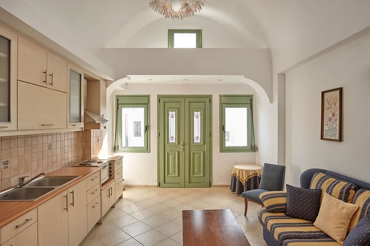 A spacious kitchen with a dining area, a sofa, and a small table.