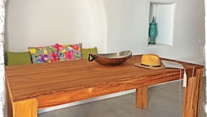 A wooden table with a bowl and a straw hat on it. - Ayoba Santorini (Santorini)