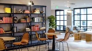 A library with bookshelves, reading chairs, and tables. - Freepoint Hotel Cambridge, Tapestry Collection by Hilton (Cambridge)