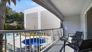 A balcony with a view of a swimming pool and a white building. - SureStay Plus Hotel by Best Western Sacramento North (Sacramento)
