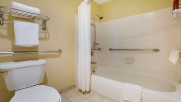 Un baño con inodoro, bañera y zona de ducha.