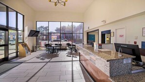 A reception area with a counter, seating, and large windows. - SureStay Plus Hotel by Best Western Sacramento North (Sacramento)