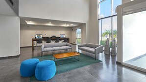 A spacious lobby with a modern design, featuring a reception desk, comfortable seating, and large windows offering views of the outdoors. - Hotel Best Place Express (Zamora)
