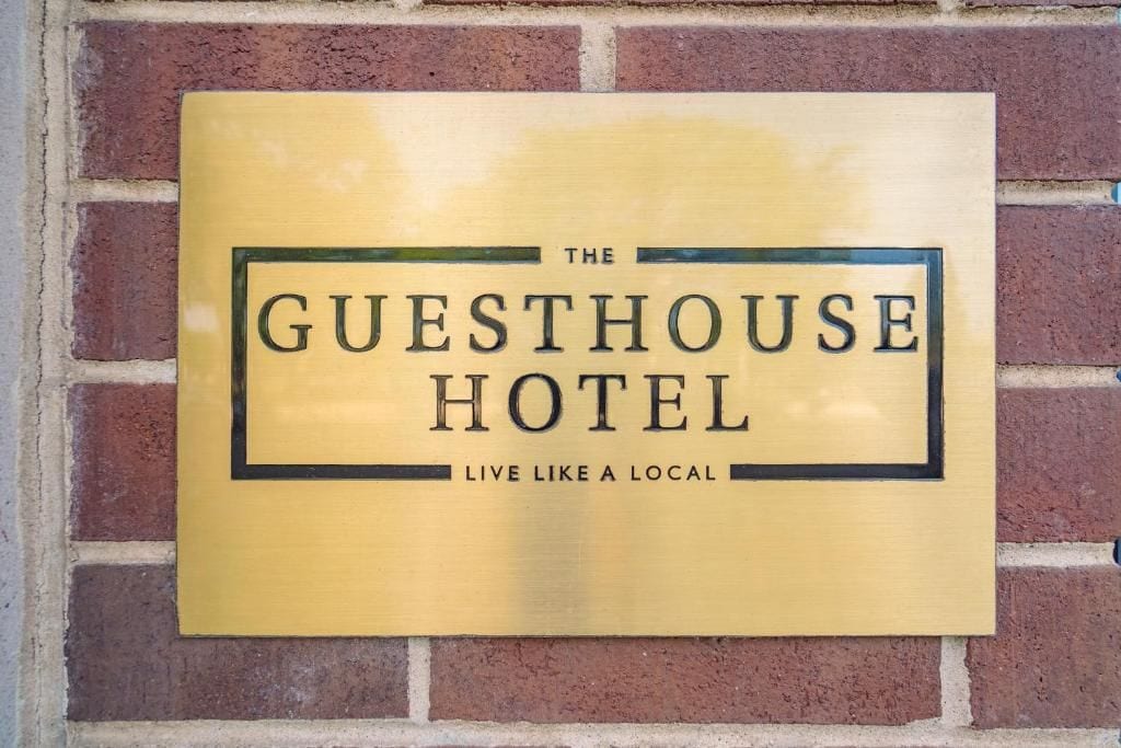 A plaque with the text 'The Guesthouse Hotel' and the tagline 'Live like a local'.