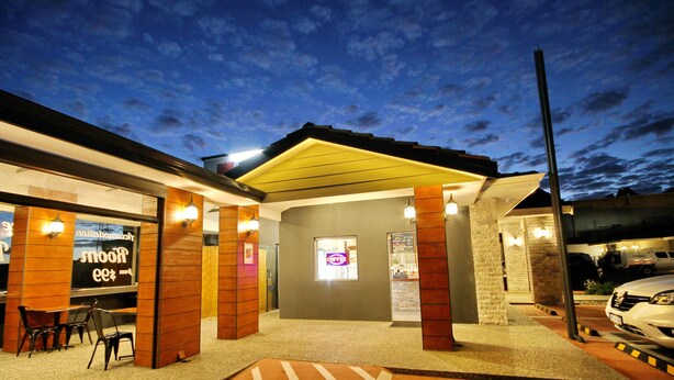 A building with a covered entrance, a coffee shop sign, and a parking area. - Gallery Hotel (Bibra Lake)