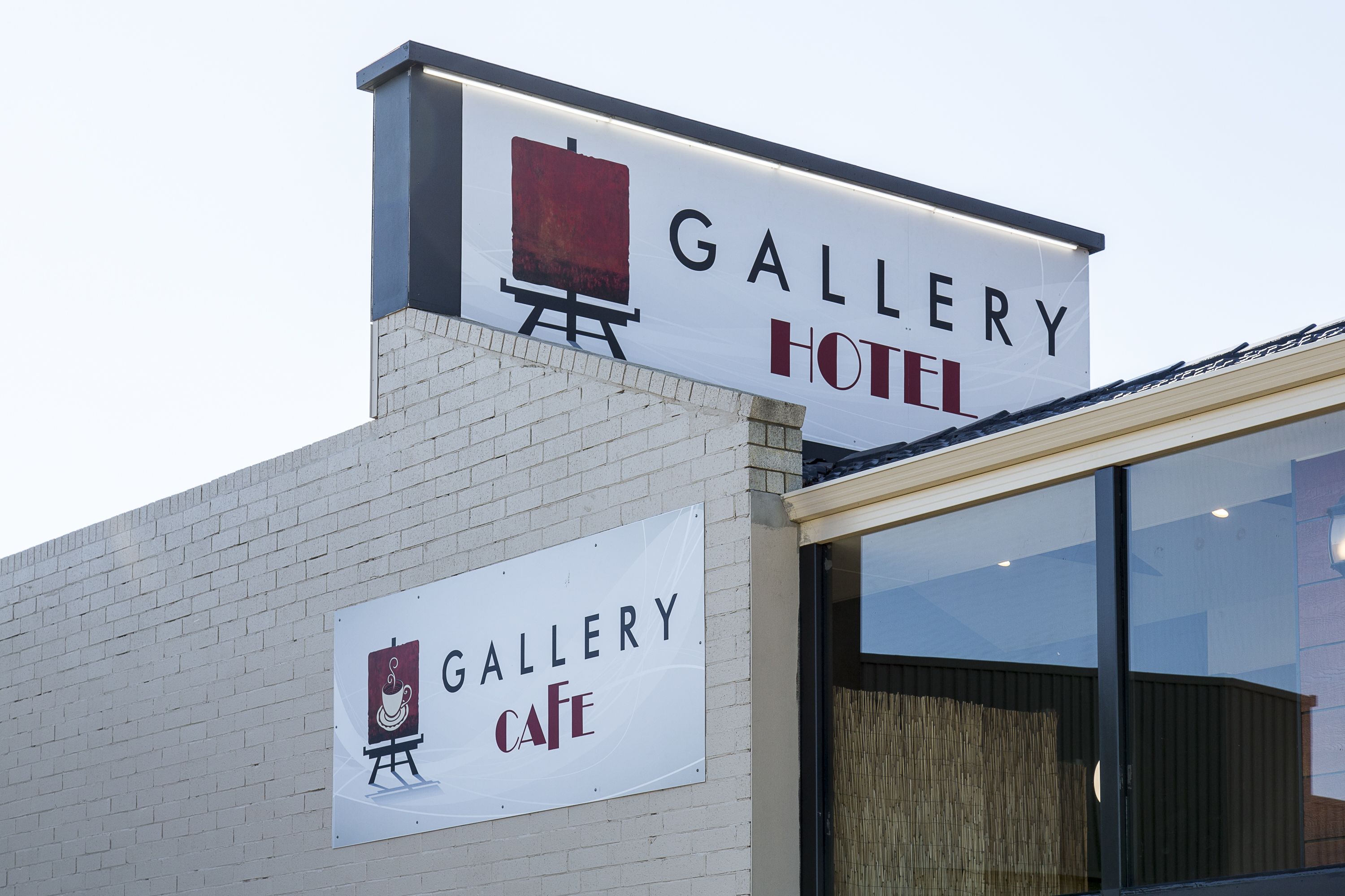Un edificio con una insegna che recita "Gallery Hotel" e un'altra insegna sottostante che dice "Gallery Cafe".