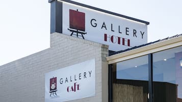 A building with a sign that reads "Gallery Hotel" and another sign below it that says "Gallery Cafe".