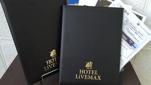 Two black binders with 'HOTEL LIVEMAX' branding and a logo, placed on a table with some papers. - Hotel LiVEMAX Kayabacho (Tokyo)