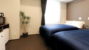 A hotel room with two beds, a small desk, a microwave, a potted plant, and a window with curtains. - Hotel LiVEMAX Kayabacho (Tokyo)
