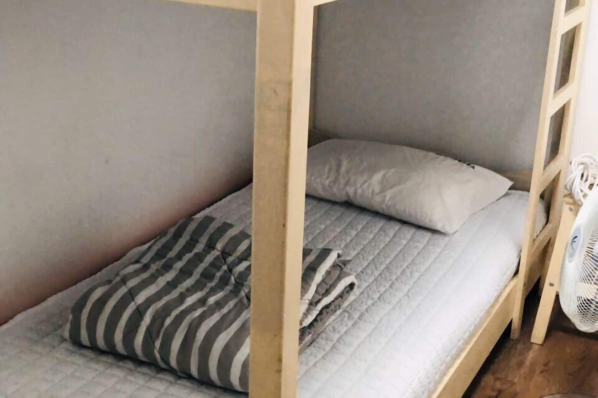 A bunk bed with a striped pillow and a plain pillow.