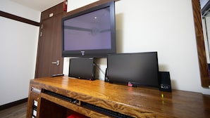 A wooden entertainment unit with a flat-screen TV, two monitors, and a sound system. - Castle Motel Iksan (Iksan)