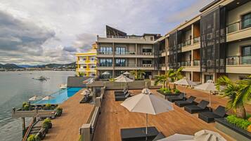 Relax by the pool surrounded by lounge chairs and umbrellas, with breathtaking views of the water.