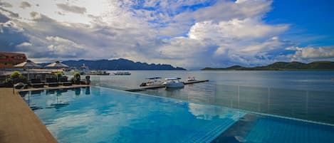 Una piscina al aire libre, sombrillas, tumbonas