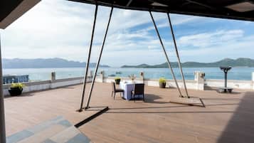 Un espacio para comer al aire libre con vistas al mar y a las montañas.