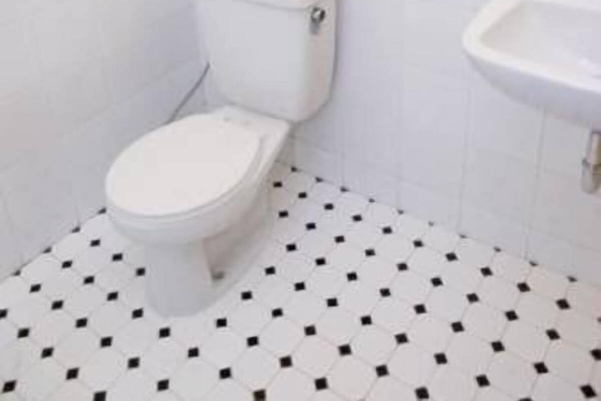 A bathroom with a white toilet, a sink, and a mirror.