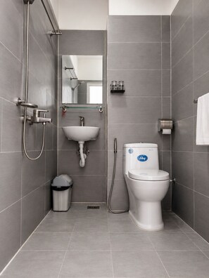 A modern bathroom with a toilet, bidet, and sink, all in a neutral color scheme. - The Lam Homestay (Phu Quoc)