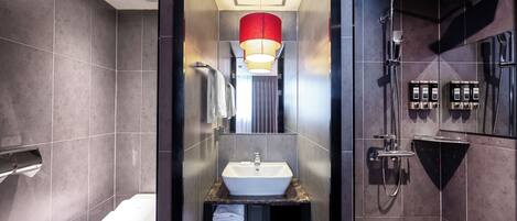 Un baño moderno con lavamanos blanco, inodoro y zona de ducha.