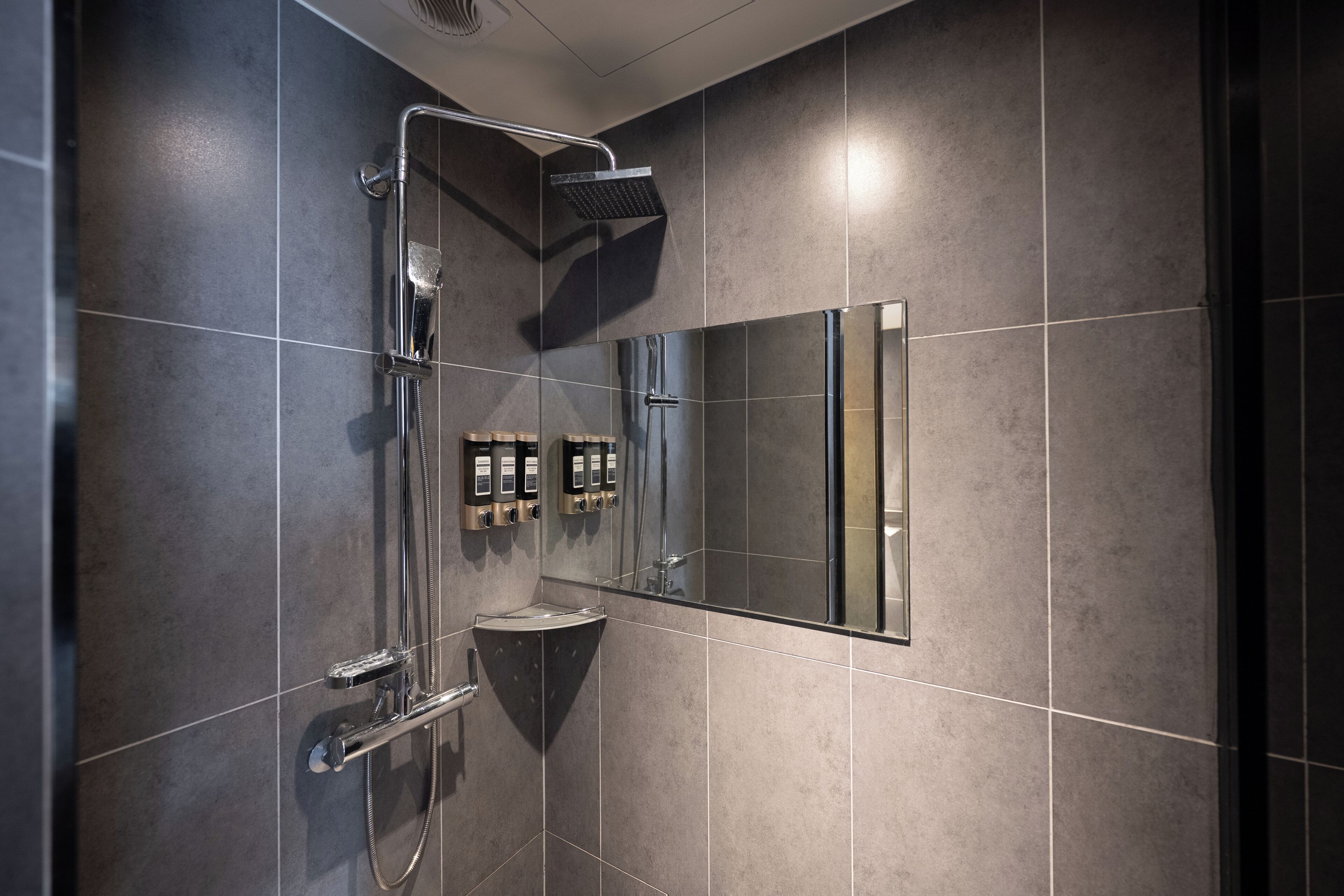 Une salle de bain moderne avec une douche, un lavabo et un miroir.