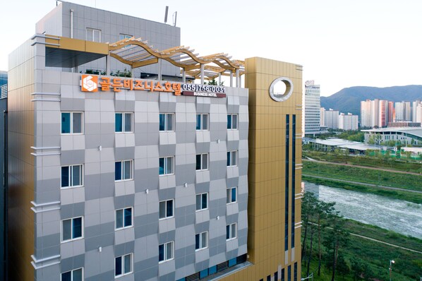 A modern business hotel with a checkered facade, multiple windows, and a prominent entrance with a canopy.