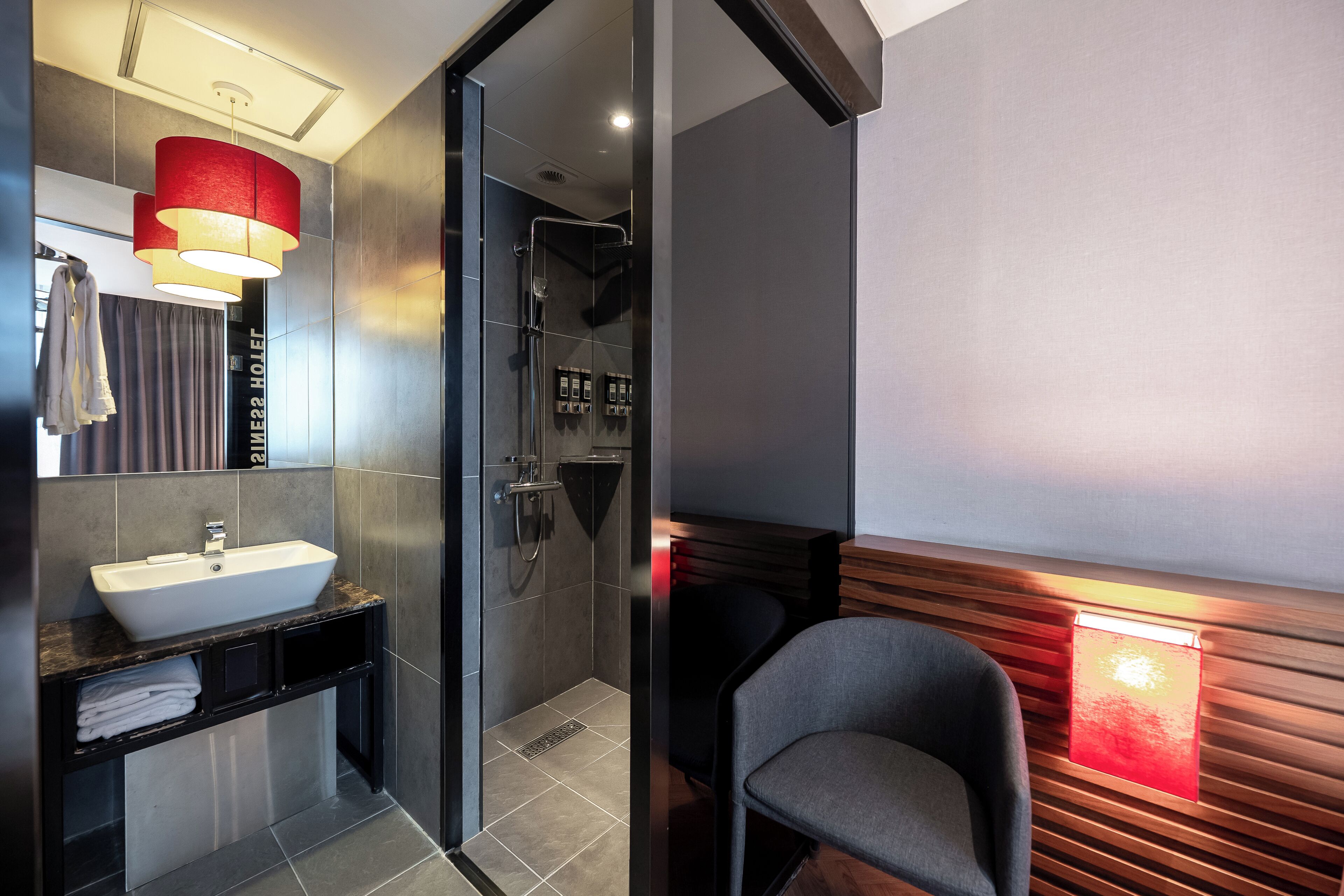 Un baño moderno con lavamanos, espejo y ducha.