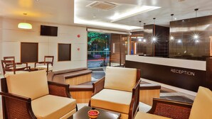 A reception area with a reception desk, seating, and a view of the outdoors. - The Link 83 Mandalay Boutique Hotel (Mandalay)