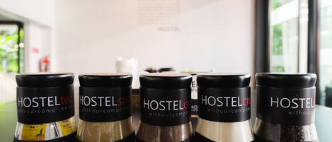 Five jars labeled 'Hostel' with different contents on a shelf.