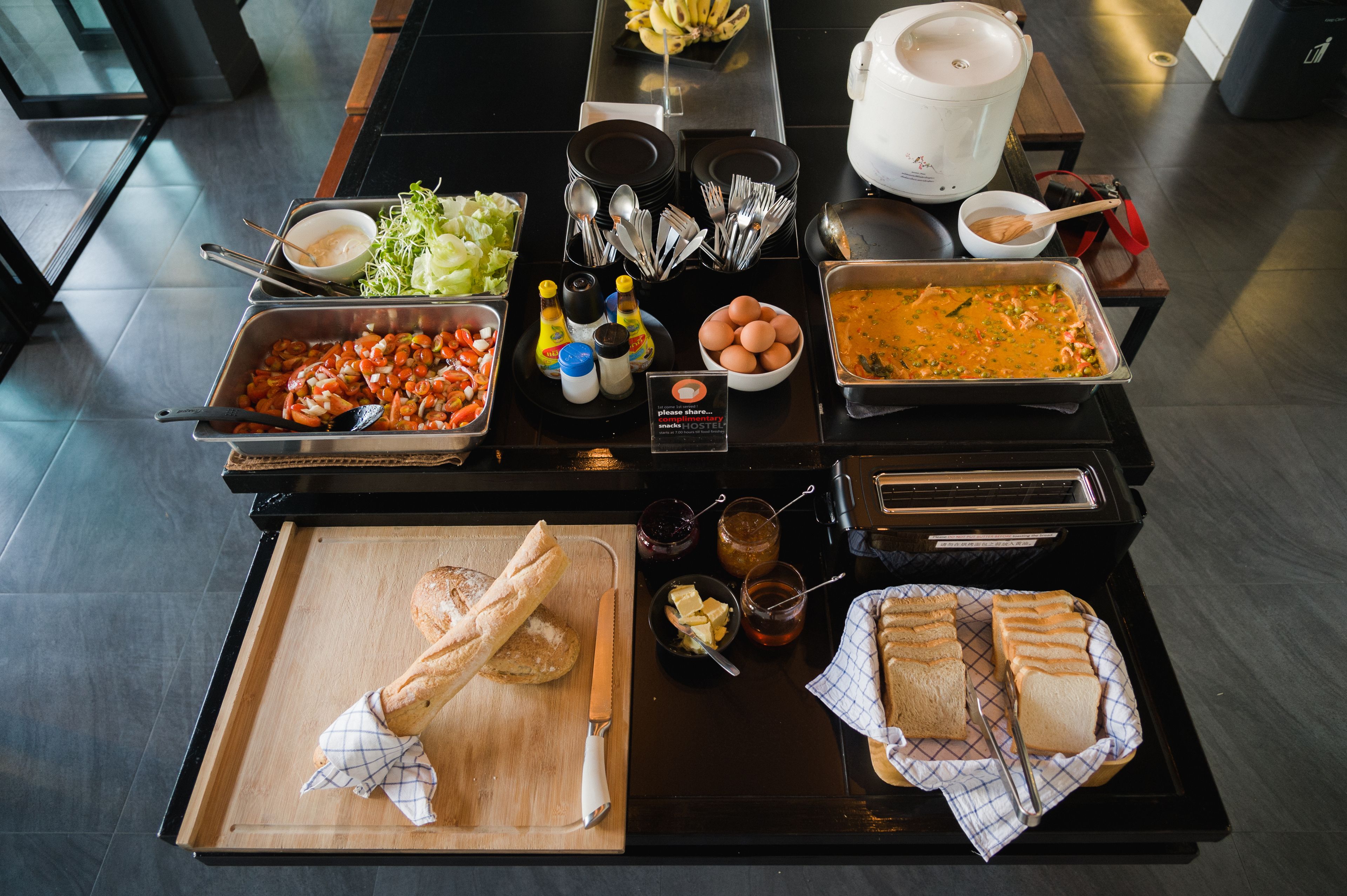 A buffet setup with various food items and utensils.