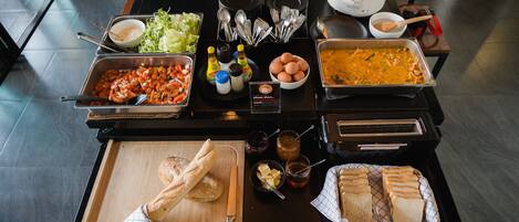 A buffet setup with various food items and utensils.