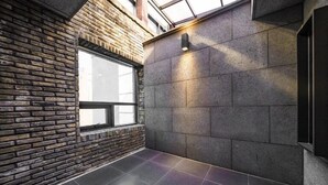 Een modern interieur met een bakstenen muur, een groot raam en een stenen muur met een lamp.
