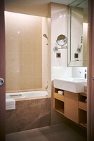 Een moderne badkamer met een bad, een wastafel en een spiegel.