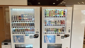 Twee automaten gevuld met drankjes en snacks.