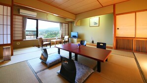 Une pièce de style japonais traditionnel, avec un sol recouvert de tatamis, une table basse et un téléviseur.