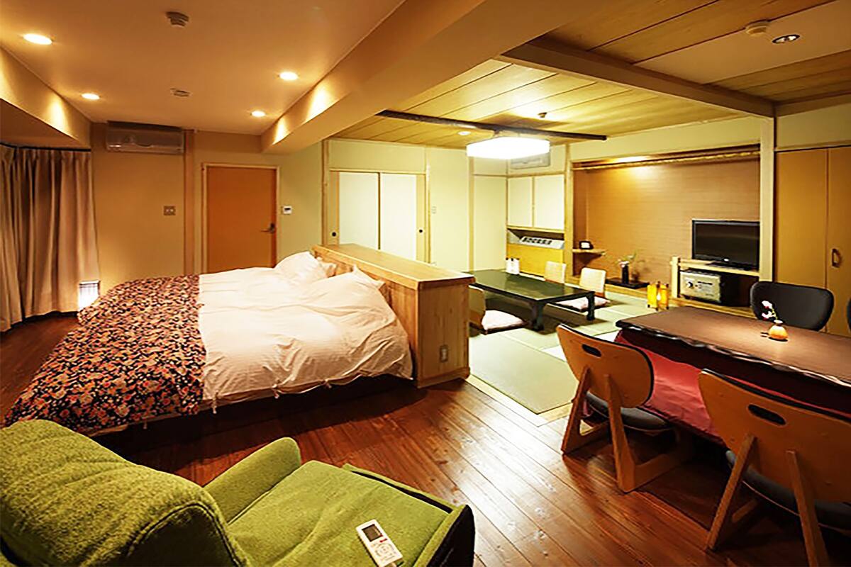 Une chambre d’hôtel équipée d’un lit, d’un bureau, d’une chaise et d’un téléviseur.