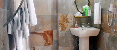 Une salle de bain avec une douche, un lavabo et un miroir.