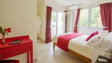 A bedroom with a bed, a desk, and a window.
