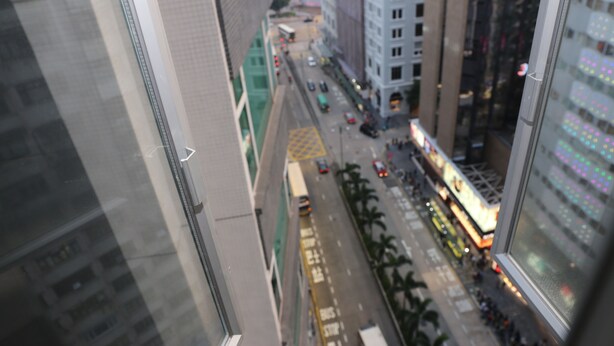Un edificio alto con vistas a una calle concurrida.