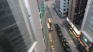 Una calle urbana con una parada de autobús, edificios y peatones.