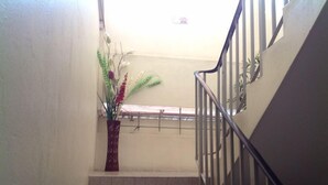 Eine Treppe mit Metallgeländer und einem Blumentopf auf der Empore.