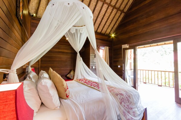 Una habitación de cabaña de madera con una cama bajo un dosel, un ventanal y techo de madera.