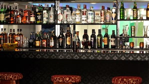 A bar with various liquor bottles and glasses. - Hotel Shivam Plaza (Kathmandu)