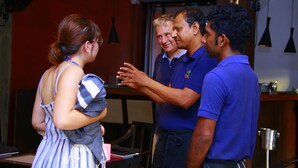 A group of people in a room with wooden walls and hanging pendant lights. - Sea port hotel (Negombo)