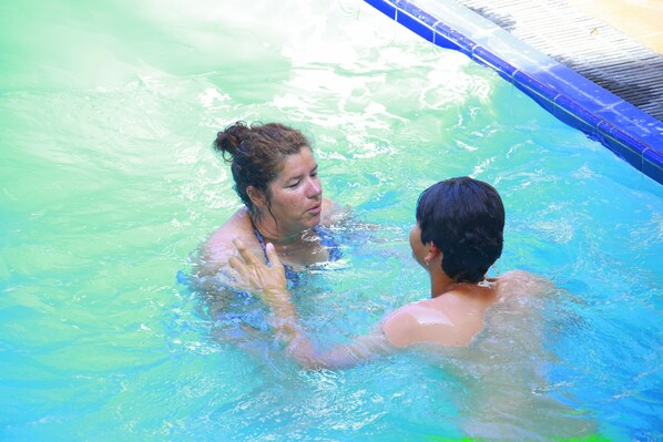 Una piscina con agua cristalina y borde azul.