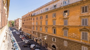 A street view of a historic building with a row of parked cars and a pedestrian walkway. - Relais Vatican Suites (Rome)
