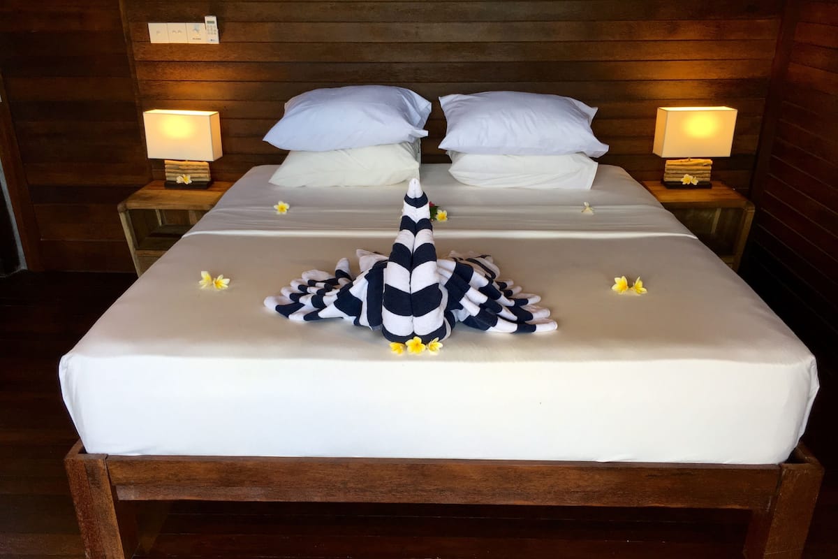 A neatly made bed with a striped blanket and a decorative pillow arrangement.