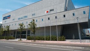 Een modern gebouw met een plat dak en een hoge vlaggenmast.