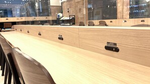 Een vergaderruimte met een lange tafel, stoelen en een klok aan de muur.