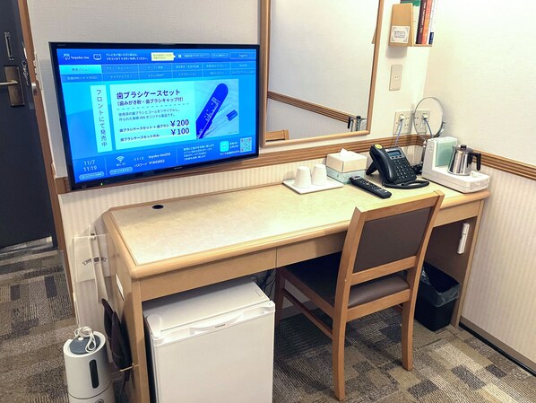 A hotel room with a desk, a computer monitor displaying a booking interface, a telephone, and a small refrigerator. - Toyoko Inn Hokkaido Sapporo Station Minami (Sapporo)