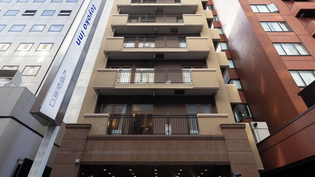 Een hotelgebouw met meerdere verdiepingen, balkons en een bord dat het als hotel identificeert.