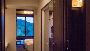 Un pasillo de hotel con una cama, un ventanal y una puerta.